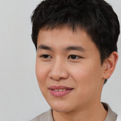 Joyful asian young-adult male with short  black hair and brown eyes