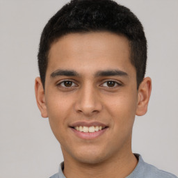 Joyful latino young-adult male with short  brown hair and brown eyes