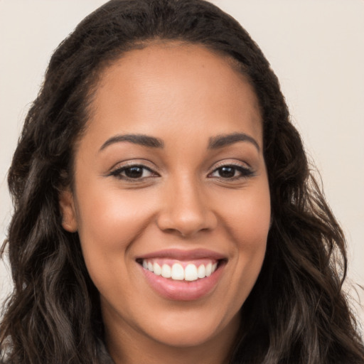 Joyful latino young-adult female with long  brown hair and brown eyes