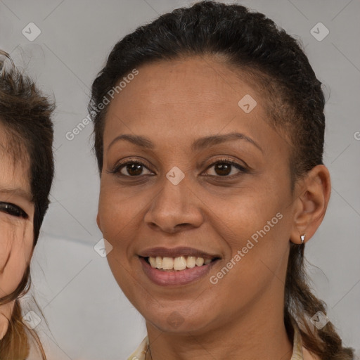 Joyful black adult female with medium  brown hair and brown eyes