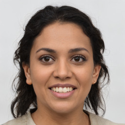 Joyful latino young-adult female with medium  brown hair and brown eyes