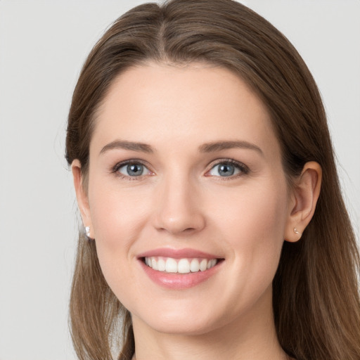 Joyful white young-adult female with long  brown hair and grey eyes