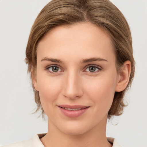 Joyful white young-adult female with medium  brown hair and grey eyes