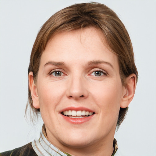 Joyful white young-adult female with medium  brown hair and grey eyes