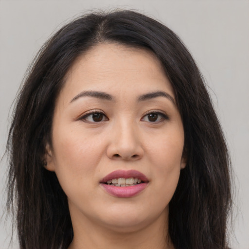 Joyful asian young-adult female with long  brown hair and brown eyes