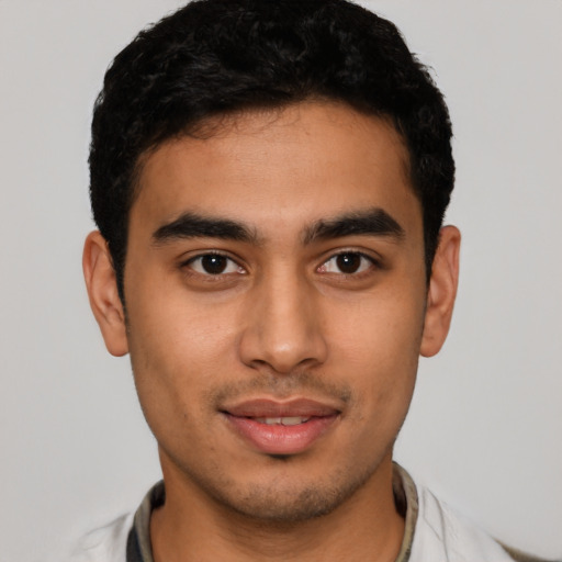 Joyful latino young-adult male with short  black hair and brown eyes