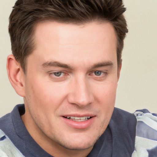 Joyful white young-adult male with short  brown hair and grey eyes