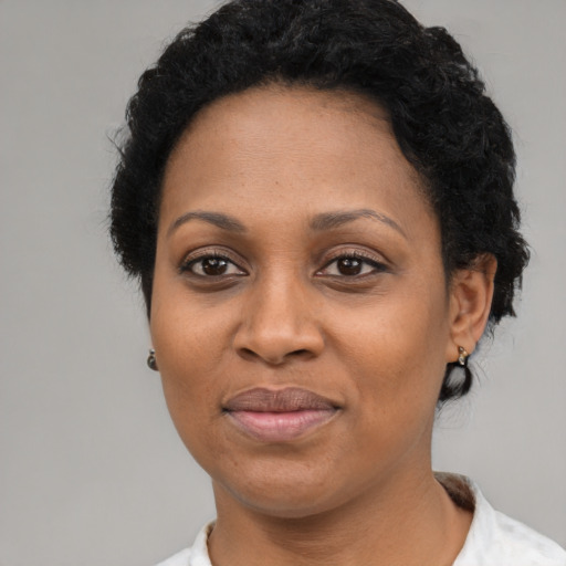 Joyful black adult female with short  black hair and brown eyes