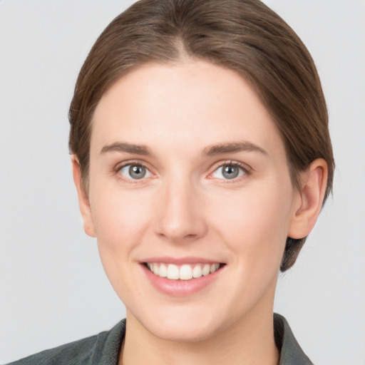 Joyful white young-adult female with medium  brown hair and grey eyes