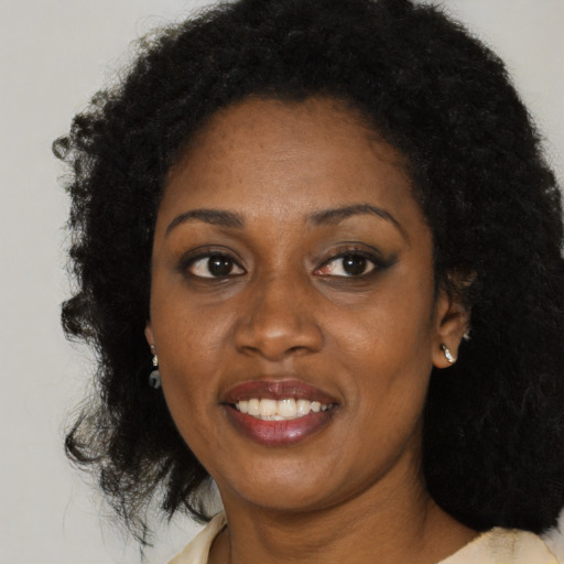 Joyful black young-adult female with medium  brown hair and brown eyes