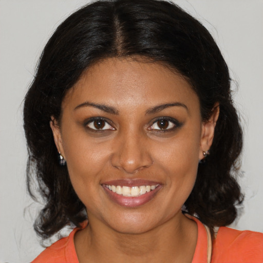 Joyful black young-adult female with medium  brown hair and brown eyes