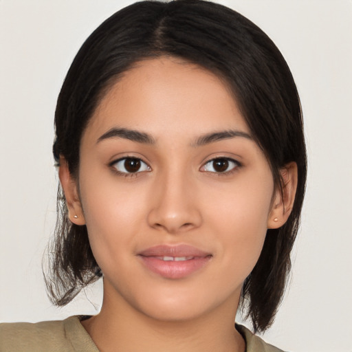 Joyful latino young-adult female with medium  brown hair and brown eyes