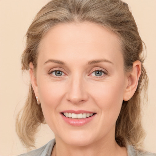 Joyful white young-adult female with medium  brown hair and blue eyes