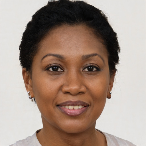 Joyful black adult female with short  black hair and brown eyes