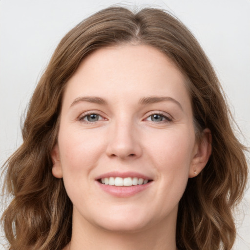 Joyful white young-adult female with long  brown hair and grey eyes