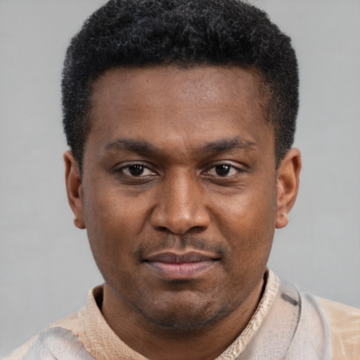 Joyful latino young-adult male with short  brown hair and brown eyes