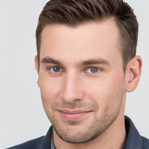 Joyful white young-adult male with short  brown hair and grey eyes