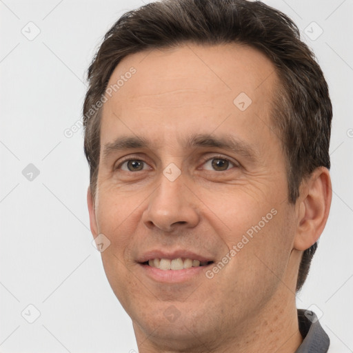 Joyful white adult male with short  brown hair and brown eyes