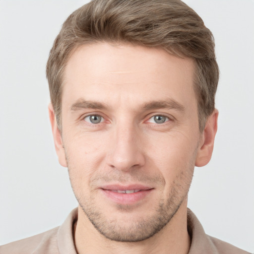 Joyful white young-adult male with short  brown hair and grey eyes