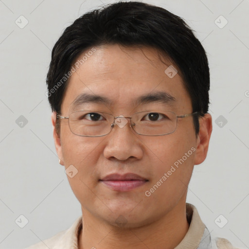 Joyful asian young-adult male with short  brown hair and brown eyes