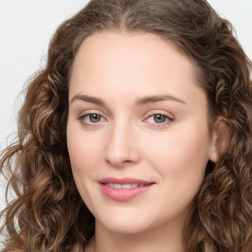 Joyful white young-adult female with long  brown hair and green eyes