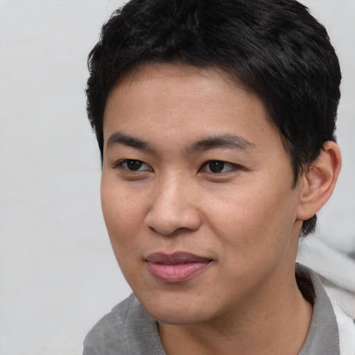 Joyful asian young-adult male with short  black hair and brown eyes