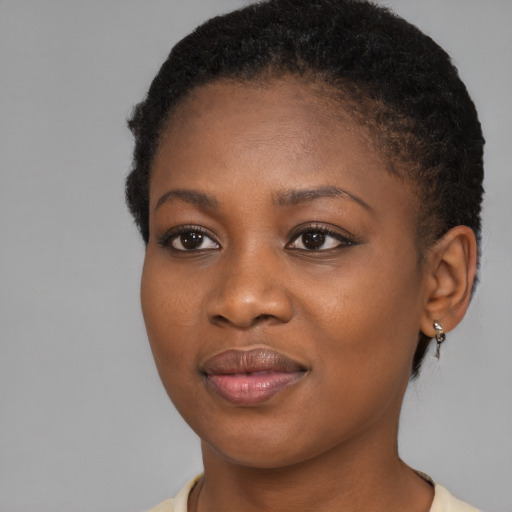 Joyful black young-adult female with short  brown hair and brown eyes