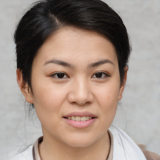 Joyful asian young-adult female with medium  brown hair and brown eyes