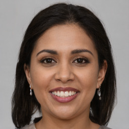 Joyful latino young-adult female with medium  brown hair and brown eyes