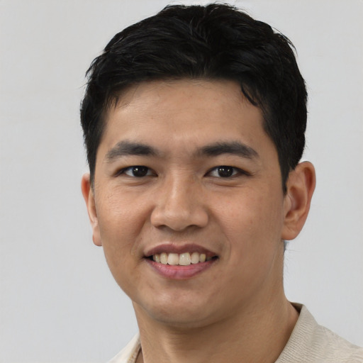 Joyful asian young-adult male with short  black hair and brown eyes