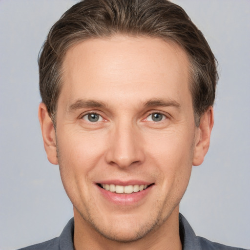 Joyful white adult male with short  brown hair and brown eyes