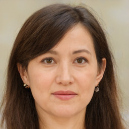 Joyful white adult female with long  brown hair and brown eyes