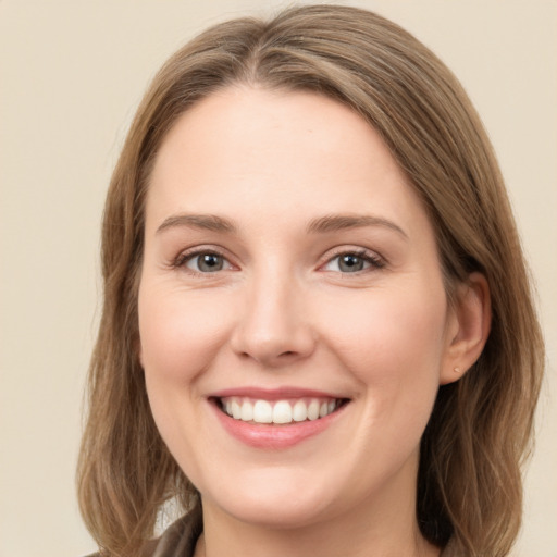 Joyful white young-adult female with long  brown hair and green eyes