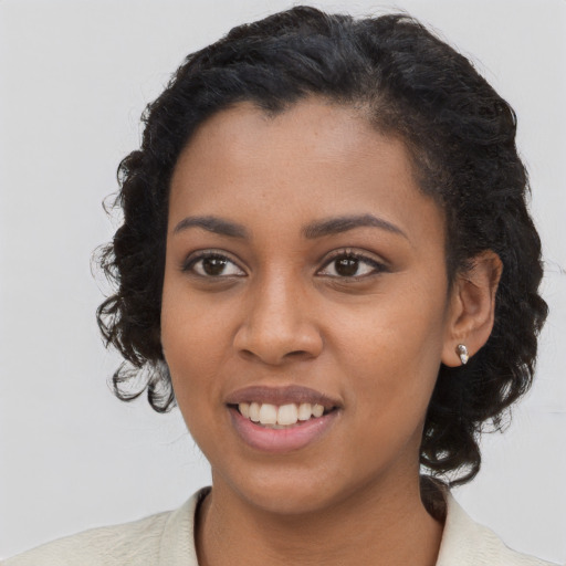 Joyful black young-adult female with long  brown hair and brown eyes