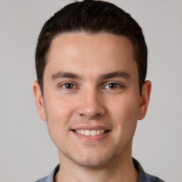 Joyful white young-adult male with short  brown hair and grey eyes