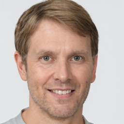 Joyful white adult male with short  brown hair and brown eyes