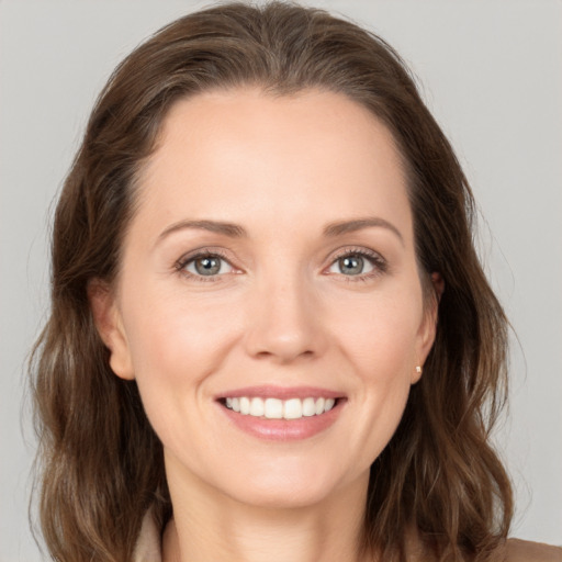 Joyful white young-adult female with long  brown hair and grey eyes