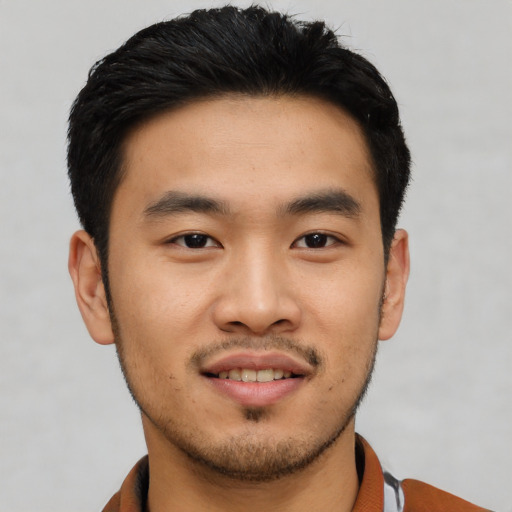 Joyful asian young-adult male with short  black hair and brown eyes