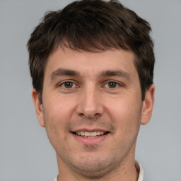 Joyful white young-adult male with short  brown hair and brown eyes