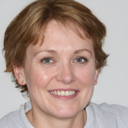 Joyful white adult female with medium  brown hair and blue eyes