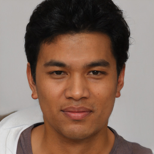 Joyful asian young-adult male with short  black hair and brown eyes