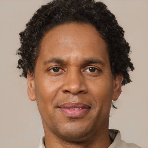 Joyful black adult male with short  brown hair and brown eyes
