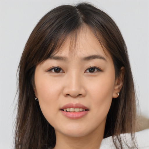 Joyful asian young-adult female with long  brown hair and brown eyes