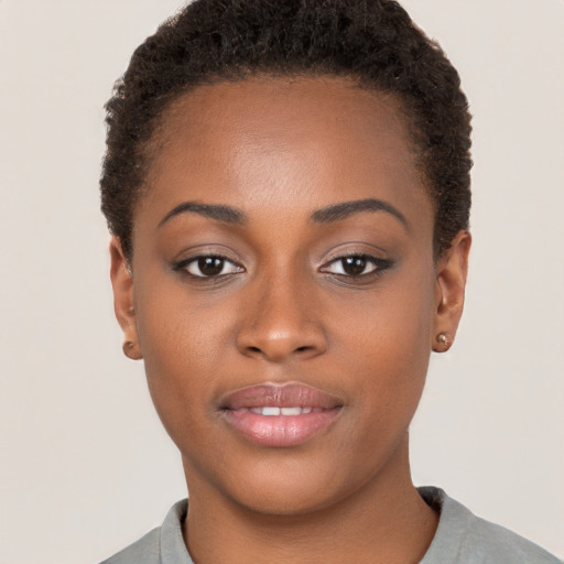 Joyful black young-adult female with short  brown hair and brown eyes