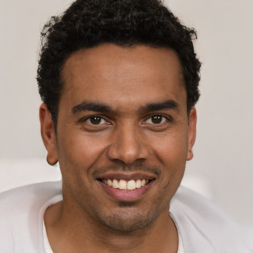 Joyful black young-adult male with short  brown hair and brown eyes