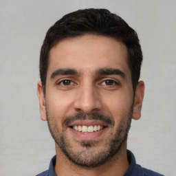 Joyful white young-adult male with short  black hair and brown eyes