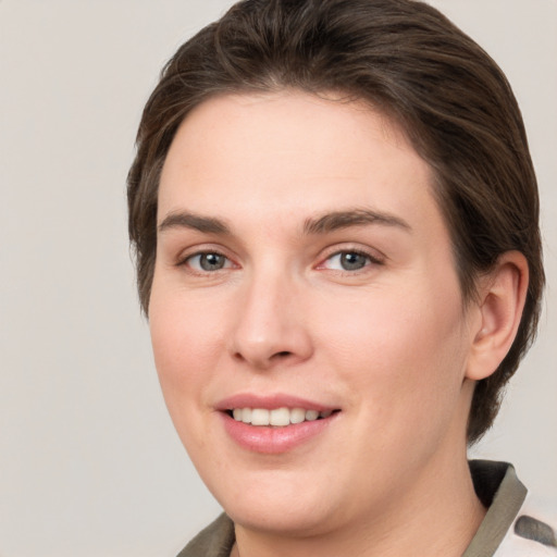 Joyful white young-adult female with medium  brown hair and grey eyes