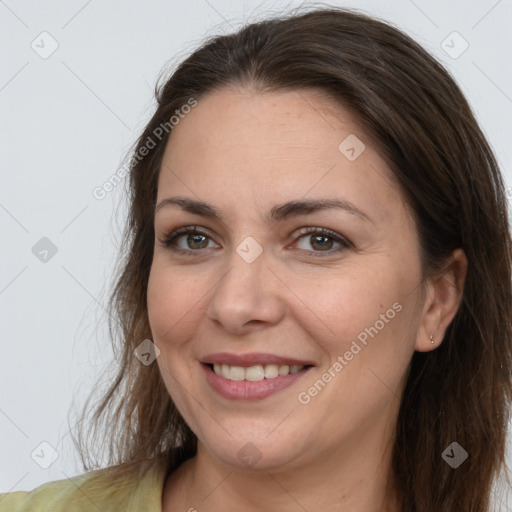 Joyful white adult female with long  brown hair and brown eyes