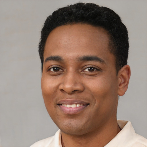 Joyful latino young-adult male with short  black hair and brown eyes