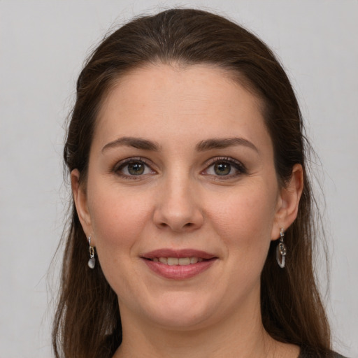 Joyful white young-adult female with long  brown hair and grey eyes